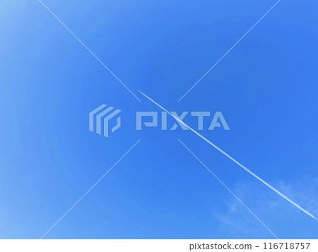 A contrail and a small aircraft floating in the blue sky A contrail and a small aircraft floating in the blue sky 116718757