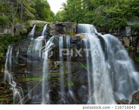 Aerial view of Whitewater Falls in Nantahala National Forest, North Carolina, USA. Clear water falling down from rocky boulders between green lush woods 116718843