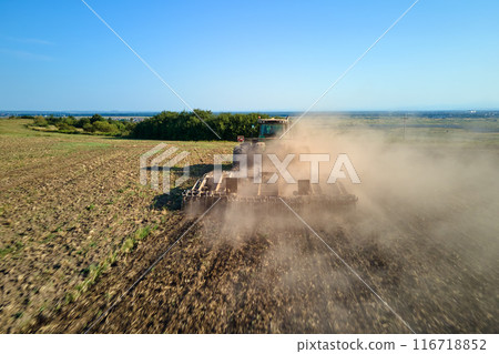 Aerial view of tractor plowing agriculural farm field preparing soil for seeding in summer 116718852