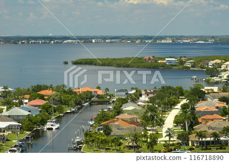 Aerial view of rural private houses in remote suburbs located on sea coast near Florida wildlife wetlands with green vegetation on gulf bay shore. Living close to nature in tropical region concept 116718890