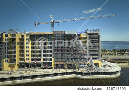 Aerial view of ruined by hurricane Ian construction scaffolding on high apartment building site in Port Charlotte, USA 116718893