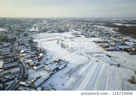 Aerial view of private homes with snow covered roofs in rural suburbs town area in cold winter Aerial view of private homes with snow covered roofs in rural suburbs town area in cold winter 116718906