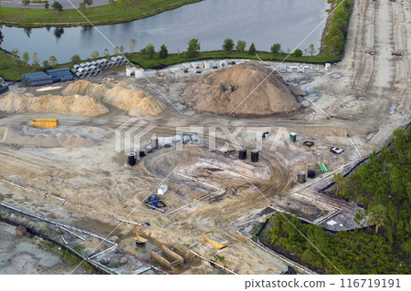 Aerial view of large construction site with building equipment on prepared soil in american rural area. Development of residential housing in US suburbs. Real estate market in the USA Aerial view of large construction site with building equipment on prepared soil in american rural area. Development of residential housing in US suburbs. Real estate market in the USA 116719191