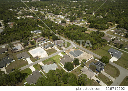 Aerial view of incompleted frame of private home under construction with brick concrete walls ready for installation of wooden roofing beams. Industrial building site Aerial view of incompleted frame of private home under construction with brick concrete walls ready for installation of wooden roofing beams. Industrial building site 116719202