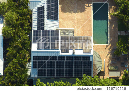 Aerial view of expensive american home with swimming pool and roof with blue solar photovoltaic panels for producing clean ecological electric energy. Renewable electricity with zero emission concept 116719216