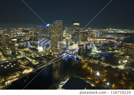 Aerial view of downtown district of Tampa city in Florida, USA. Brightly illuminated high skyscraper buildings, pedestrian riverwalk and moving traffic in modern american midtown 116719220