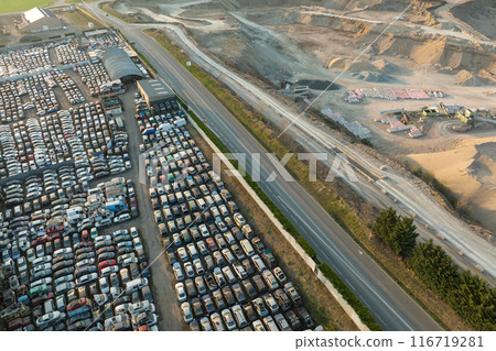 Aerial view of big parking lot of junkyard with rows of discarded broken cars. Recycling of old vehicles Aerial view of big parking lot of junkyard with rows of discarded broken cars. Recycling of old vehicles 116719281