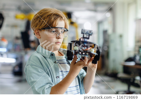 Portrait of schoolboy building robotic car in after-school robotics club. Children learning robotics in Elementary school. Science for kids. 116719869