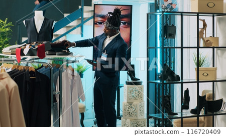 African american employee giving advice to senior customer in retail store, trying to find an elegant shirt on sale. Elderly client asking assistant for suggestions and recommendations. Camera A. African american employee giving advice to senior customer in retail store, trying to find an elegant shirt on sale. Elderly client asking assistant for suggestions and recommendations. Camera A. 116720409