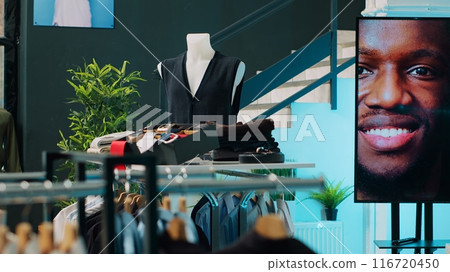 Shopping center having elegant shirts and suits on display, selling fashionable items and accessories. Empty clothing store at mall filled with formal or casual wear, consumerism concept. Camera A. Shopping center having elegant shirts and suits on display, selling fashionable items and accessories. Empty clothing store at mall filled with formal or casual wear, consumerism concept. Camera A. 116720450