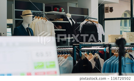 Empty fashion store selling modern clothing and accessories, having trendy shoes and bags on showroom display. Interior of fashionable clothes shop, stands with shirts and pants on racks. Camera A. Empty fashion store selling modern clothing and accessories, having trendy shoes and bags on showroom display. Interior of fashionable clothes shop, stands with shirts and pants on racks. Camera A. 116720502