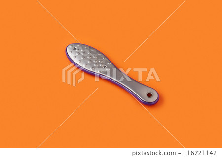 Metal pedicure tool on orange background. Beauty salon concept Metal pedicure tool on orange background. Beauty salon concept 116721142