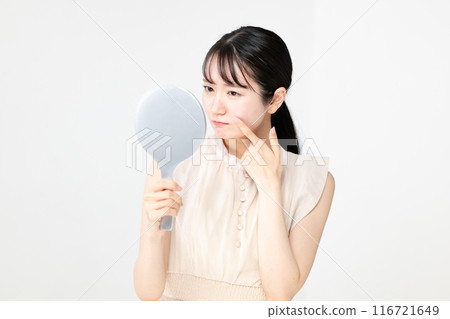 A woman troubled watching a mirror A woman troubled watching a mirror 116721649