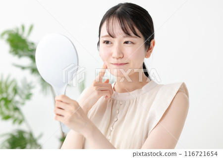 A woman troubled watching a mirror 116721654