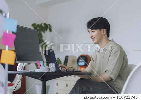 A man in his 20s working on a computer 116722743