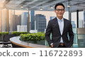 Smiling male businessman standing in the office 116722893