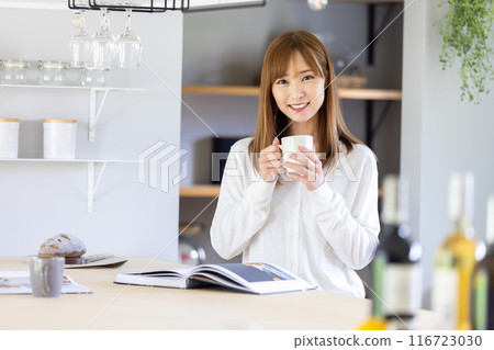 A woman standing in the kitchen with a smile A woman standing in the kitchen with a smile 116723030