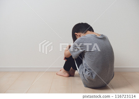 Boy holding his knees and drooping Boy holding his knees and drooping 116723114