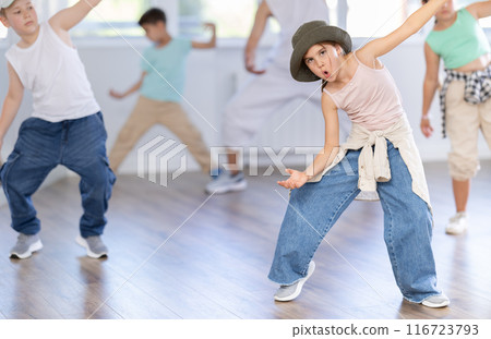 Preteen girl practicing hip hop choreography with peers and instructor Preteen girl practicing hip hop choreography with peers and instructor 116723793