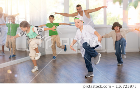 Portrait of active teen boy enjoying modern energetic dancing in group at dance studio Portrait of active teen boy enjoying modern energetic dancing in group at dance studio 116723975