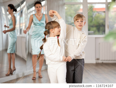 Boy with girl dressed in sport wear train to dance waltz during classes. 116724107