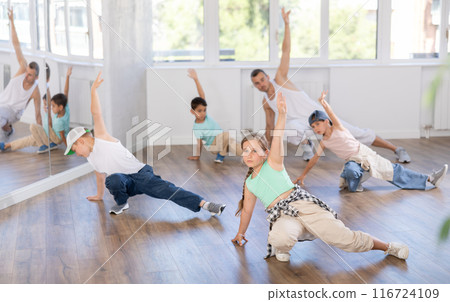 Preteen boys and girls studying movement of contemporary dance in classroom with his friends Preteen boys and girls studying movement of contemporary dance in classroom with his friends 116724109