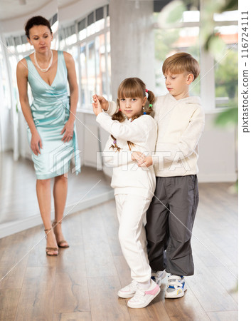 Boy with girl dressed in sport wear train to dance waltz during classes. 116724111