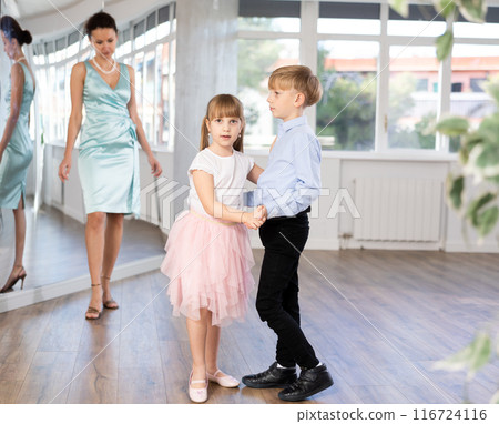 Boy and girl in pair train to dance contemporary vigorous waltz during classes. 116724116