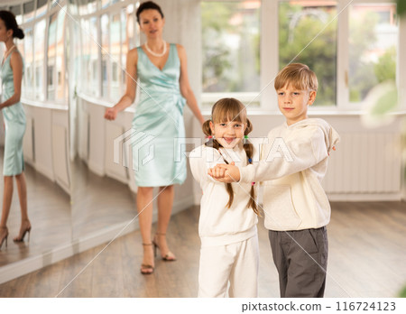 Boy with girl dressed in sport wear train to dance waltz during classes. Boy with girl dressed in sport wear train to dance waltz during classes. 116724123