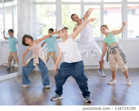 Preteen boy doing hip hop dance during group class 116724190