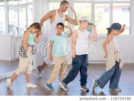 Group of preteen kids in hip hop dance class posing with instructor Group of preteen kids in hip hop dance class posing with instructor 116724196