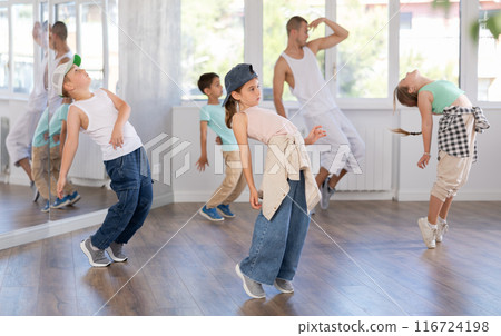 Preteen girl practicing hip hop choreography with peers and instructor Preteen girl practicing hip hop choreography with peers and instructor 116724198