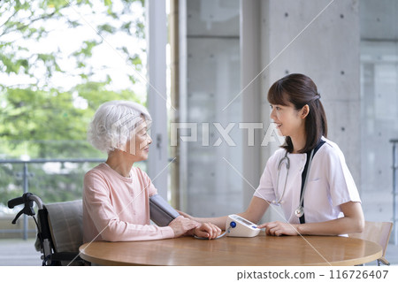 Senior woman having her blood pressure measured by a nurse Senior woman having her blood pressure measured by a nurse 116726407