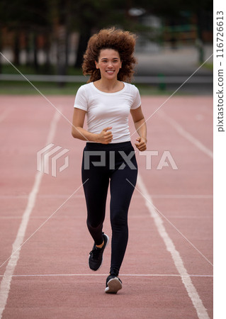 Beautiful curly Asian woman running on the street 116726613