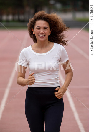 Beautiful curly Asian woman running on the street Beautiful curly Asian woman running on the street 116726621