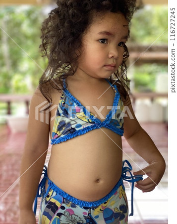 Portrait of a cute smiling little Asian girl in blue swimsuit 116727245