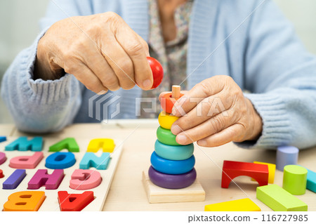 Alzheimer disease AD, Asian elderly woman patient suffering from dementia learn practical motor skills rehabilitation. 116727985