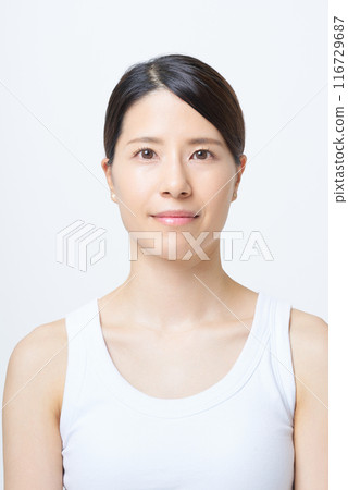 A woman in a tank top standing in front of a white background 116729687
