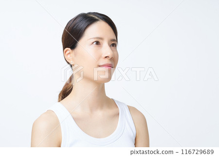 A woman in a tank top standing in front of a white background 116729689