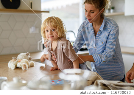Mom and kids making pancakes together. Parent and children in kitchen, preparing pancake batter, spending weekend day indoors. Mom and kids making pancakes together. Parent and children in kitchen, preparing pancake batter, spending weekend day indoors. 116730083