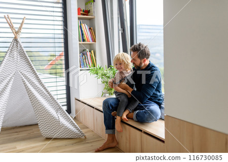 Father holding little daughter in arms, kissing her forehead. Dad enjoying fatherly moment. ather's day. 116730085