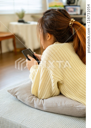 Woman embraces digital world from comfort of home. 116731054