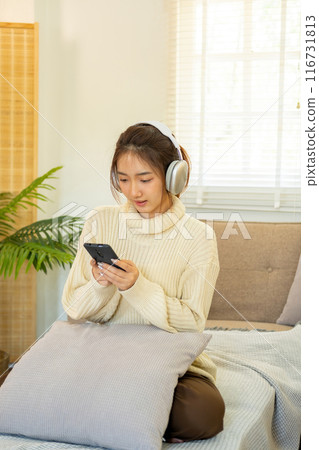 Woman listening to music for relaxation on the couch. 116731813