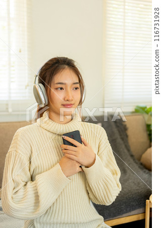 Woman listening to music for relaxation on the couch. Woman listening to music for relaxation on the couch. 116731928