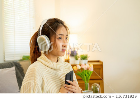 Woman listening to music for relaxation on the couch. Woman listening to music for relaxation on the couch. 116731929
