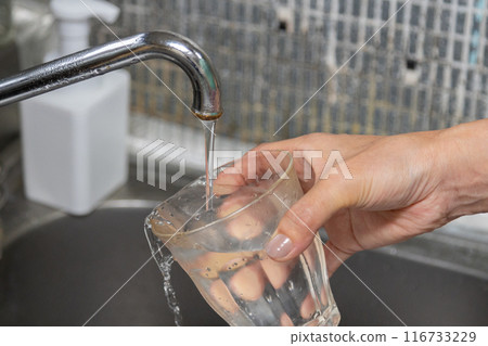 Pouring tap water into a glass - Is it safe to drink tap water? Pouring tap water into a glass - Is it safe to drink tap water? 116733229