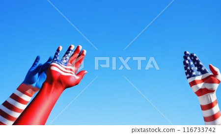Hands painted with American flag colors reaching up against blue sky. 116733742