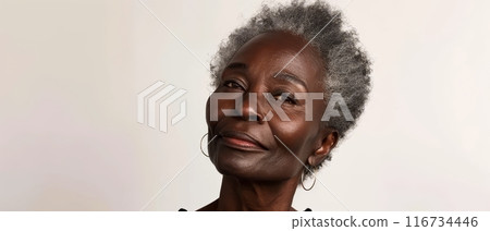 A sophisticated portrait showcasing a mature woman with a reflective gaze and striking silver hair. Her confident pose speaks to a life rich with stories and experiences. 116734446