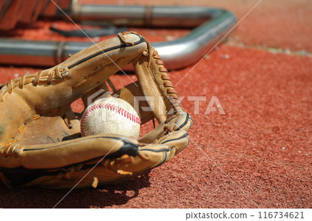 An old baseball glove and baseball lie on the lawn 116734621