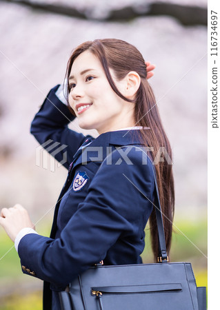 A high school girl goes to school with cherry blossoms in full bloom to welcome the new semester. 116734697